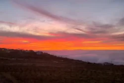 Vurige zonsondergang op Tenerife boven wolkenzee en silhouet landschap.